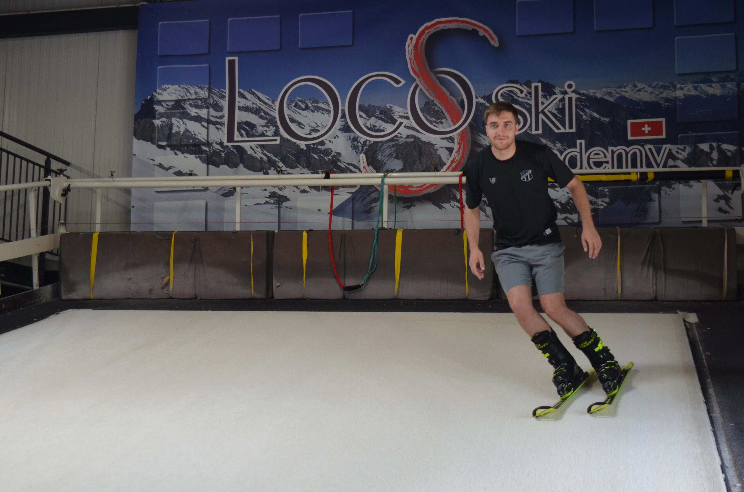 Un skieur s'entraîne sur le tapis de ski indoor.